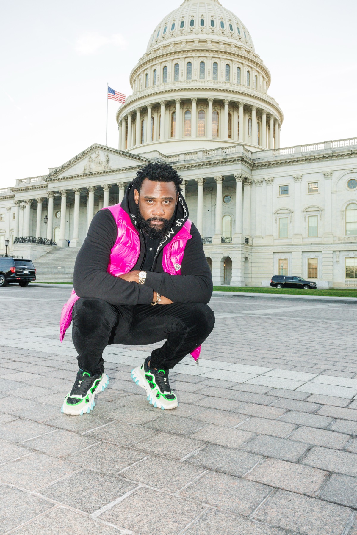 Rod212 crouched in front of the U.S. Capitol in a pink vest